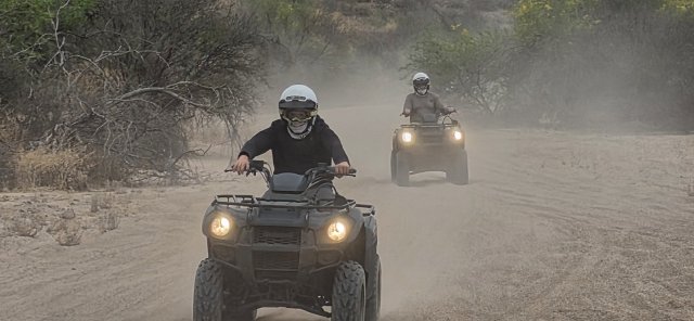 Two solo ATVs charging through the dust on a Scottsdale ATV tour
