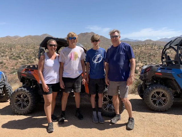 Family posing next to off-road vehicles in the Sonoran Desert