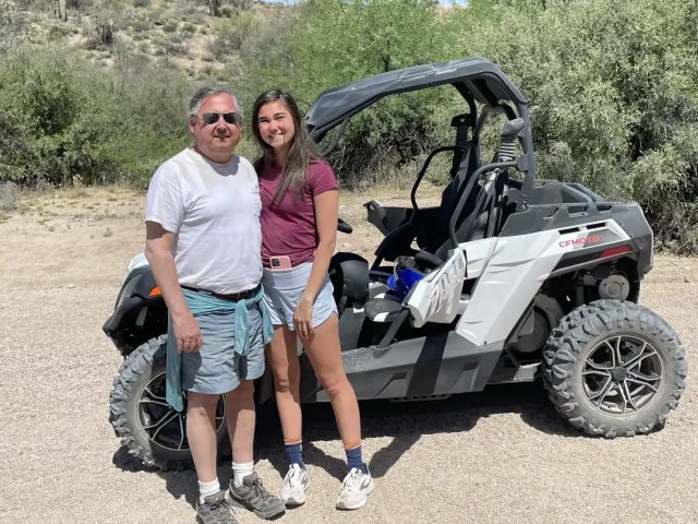 Father and daughter beside a sand buggy in the desert