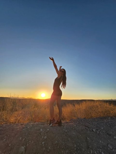 Rider silhouetted with arm raised at a Sonoran Desert sunset