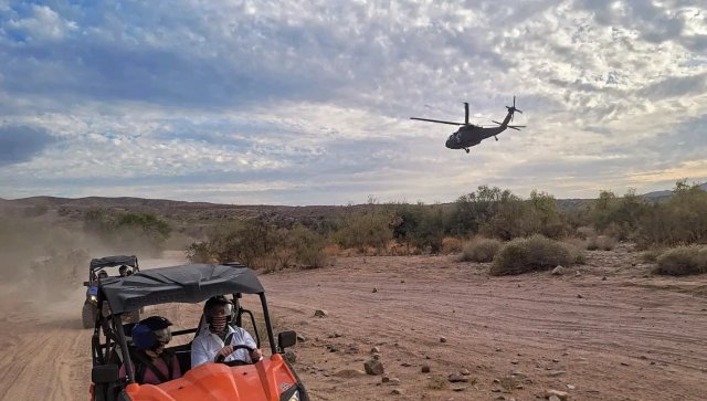 UTV on the trail as a helicopter flies over the Sonoran Desert